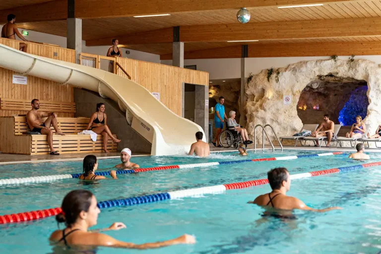 Personnes dans la piscine avec toboggan au Calypso centre aquatique et sauna