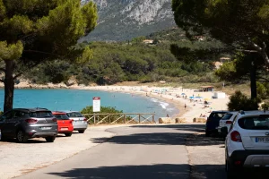 Route menant à la plage de Paulilles avec voitures, sable, mer turquoise et pins environnants